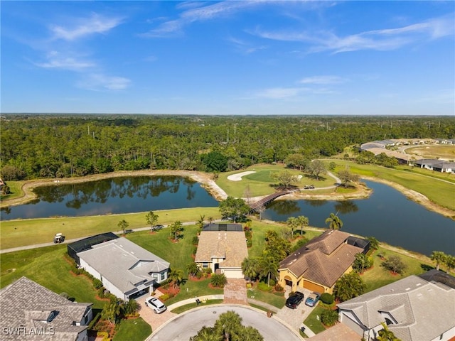 drone / aerial view featuring a forest view and a water view