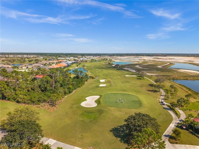 birds eye view of property with view of golf course and a water view