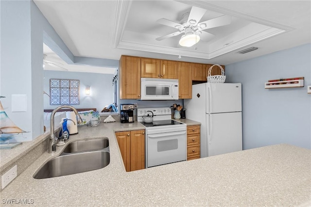 kitchen featuring a raised ceiling, light countertops, visible vents, a sink, and white appliances