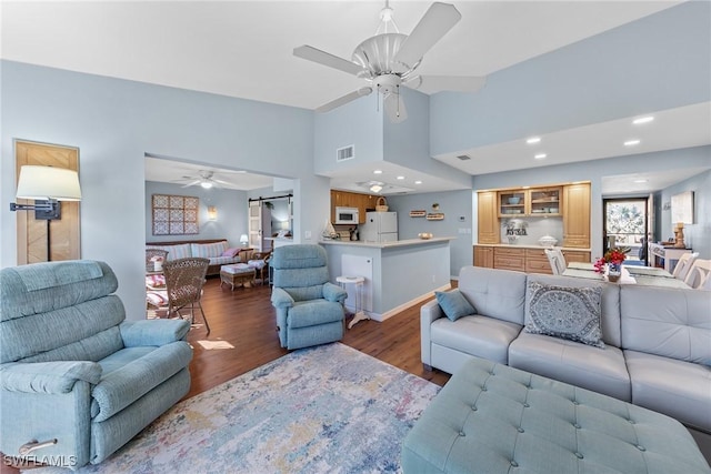 living room with ceiling fan, high vaulted ceiling, recessed lighting, wood finished floors, and visible vents