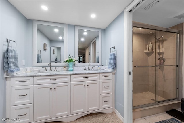 full bath with double vanity, a stall shower, visible vents, and a sink