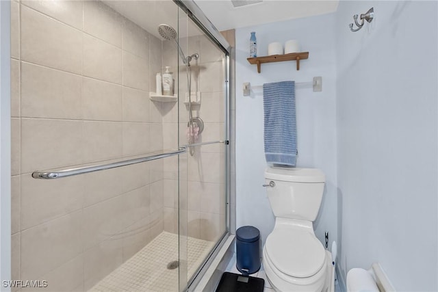 bathroom featuring toilet and a stall shower