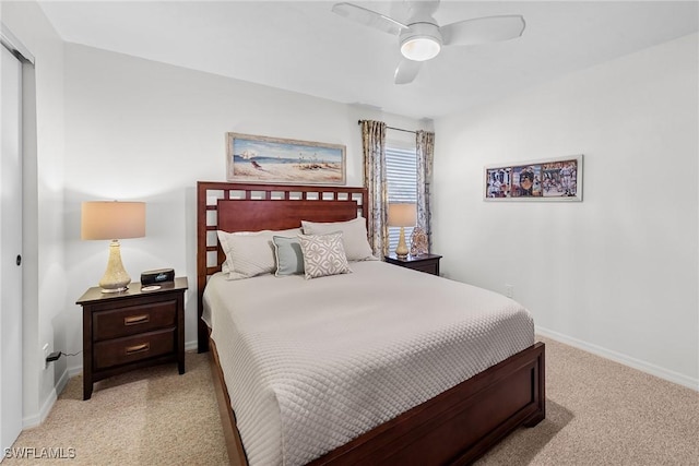 bedroom with light carpet, a ceiling fan, baseboards, and a closet