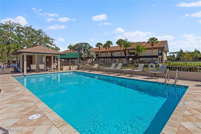 community pool featuring fence and a patio