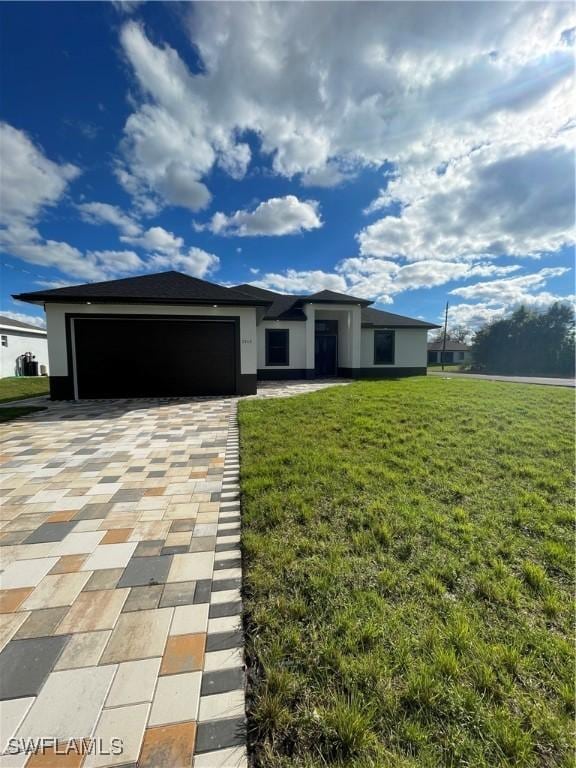 view of front facade featuring decorative driveway, an attached garage, and a front lawn