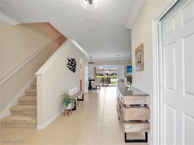 entrance foyer with light tile patterned floors, ornamental molding, a chandelier, baseboards, and stairs