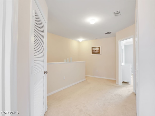 carpeted spare room featuring visible vents and baseboards