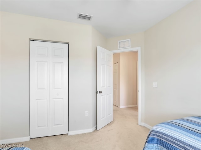 bedroom with visible vents, light carpet, and baseboards