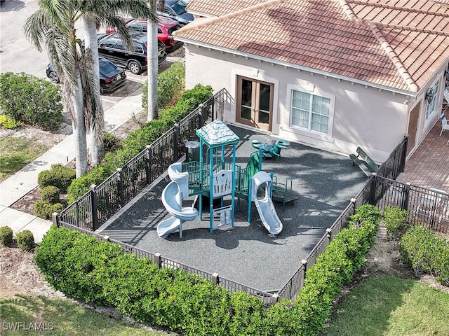 exterior space featuring french doors, playground community, and fence