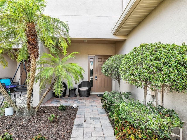 view of exterior entry with stucco siding