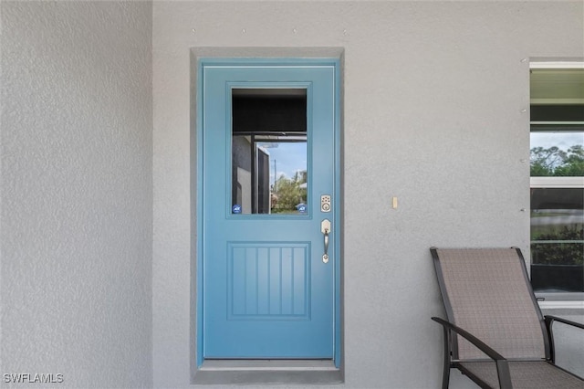 view of exterior entry with stucco siding