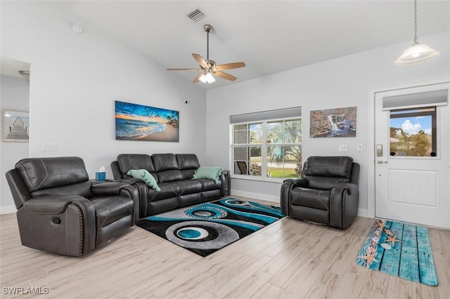 living area with vaulted ceiling, baseboards, visible vents, and light wood-style floors