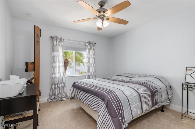 bedroom featuring a ceiling fan, light colored carpet, and baseboards