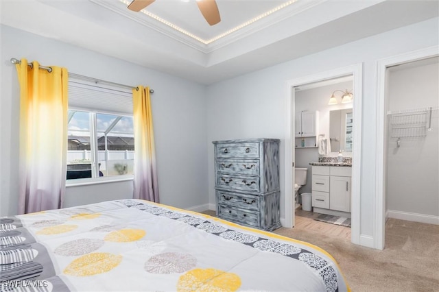 bedroom featuring light carpet, baseboards, a tray ceiling, and crown molding