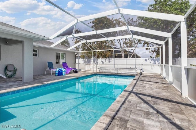 view of pool with glass enclosure, a fenced backyard, a patio area, and a fenced in pool