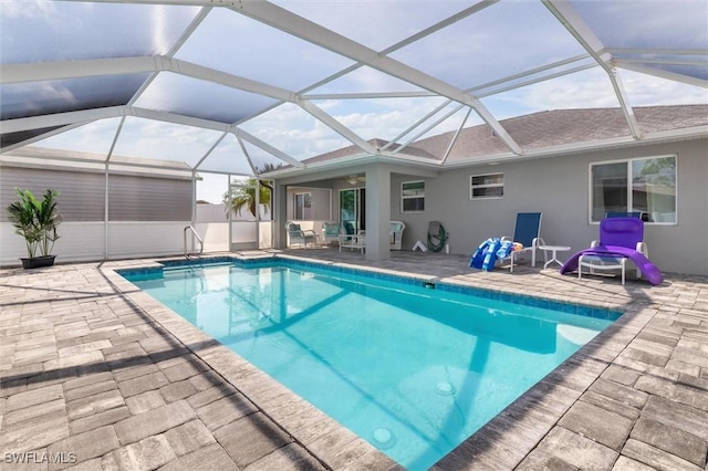 outdoor pool with glass enclosure and a patio area