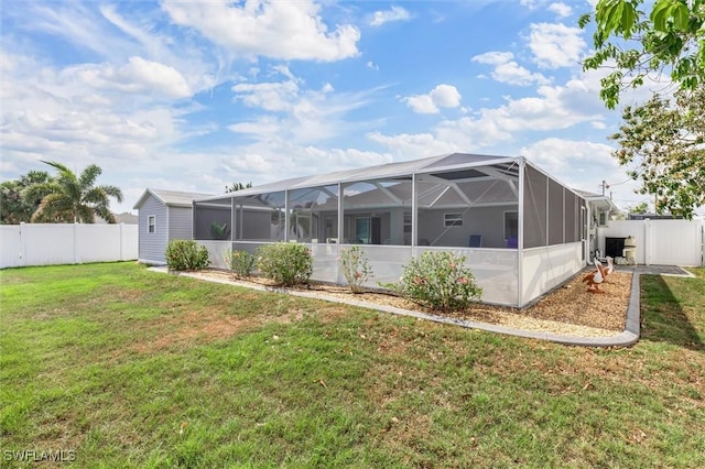 rear view of property featuring glass enclosure, a fenced backyard, and a yard