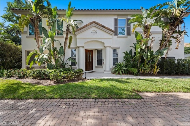 mediterranean / spanish house with a tiled roof and stucco siding