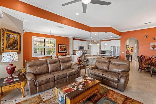 living area featuring recessed lighting, visible vents, arched walkways, ornamental molding, and ceiling fan with notable chandelier