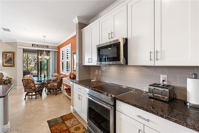 kitchen with tasteful backsplash, visible vents, white cabinets, ornamental molding, and stainless steel appliances