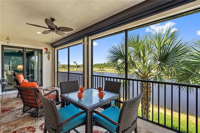 sunroom with a water view and a ceiling fan