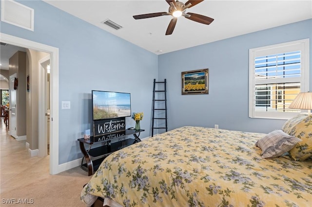 bedroom with light colored carpet, visible vents, and multiple windows