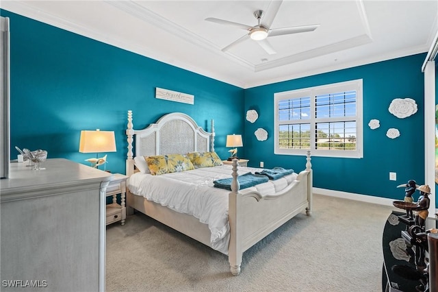 bedroom with baseboards, a raised ceiling, a ceiling fan, ornamental molding, and carpet flooring