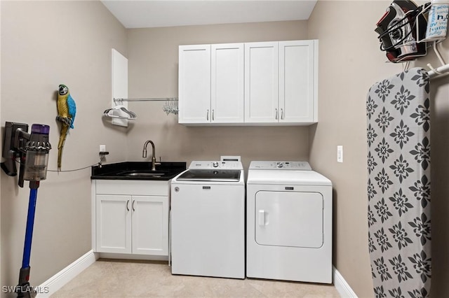 laundry room featuring independent washer and dryer, a sink, cabinet space, and baseboards