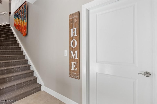 stairs with tile patterned flooring and baseboards