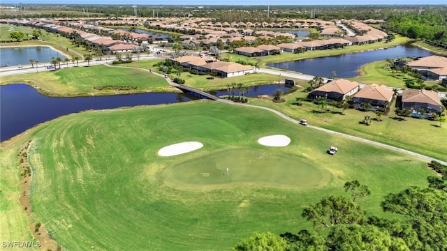 bird's eye view with golf course view, a water view, and a residential view