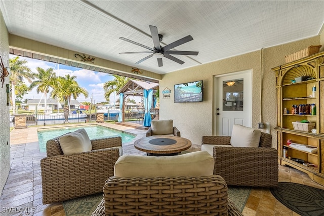 view of patio / terrace with a ceiling fan, an outdoor pool, and fence