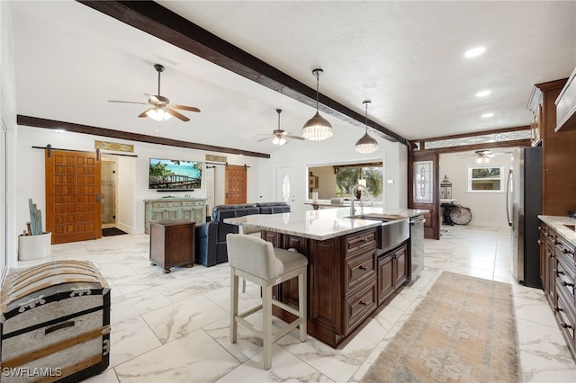 kitchen with marble finish floor, a barn door, and a sink