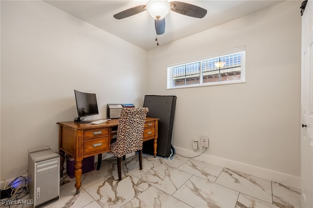 home office with marble finish floor, a ceiling fan, and baseboards