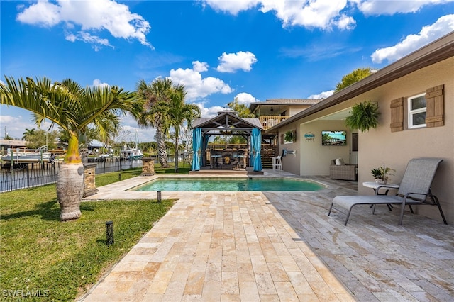 view of swimming pool featuring a fenced in pool, a lawn, a patio, fence, and a gazebo