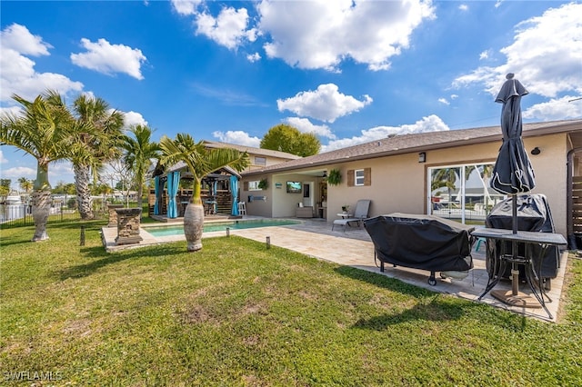 back of property featuring an outdoor pool, fence, a yard, a patio area, and stucco siding