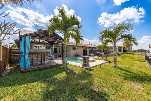 rear view of property featuring a lawn, a fenced backyard, a jacuzzi, a deck, and a gazebo