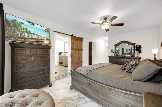 bedroom featuring marble finish floor, a barn door, connected bathroom, and a ceiling fan