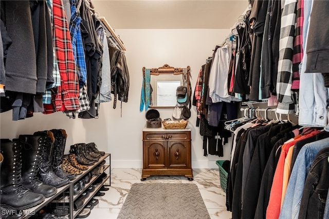 walk in closet with marble finish floor