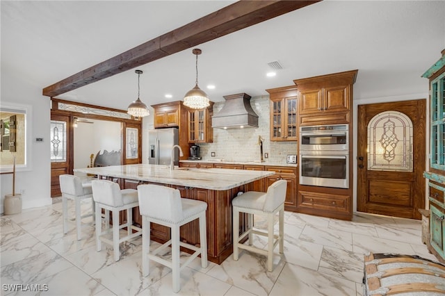 kitchen with marble finish floor, appliances with stainless steel finishes, custom exhaust hood, and visible vents