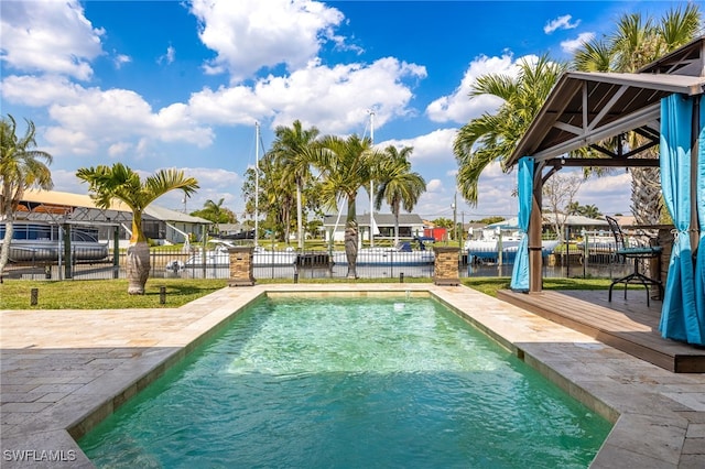 view of swimming pool featuring a boat dock and fence