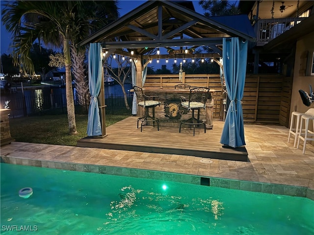 view of swimming pool with a fenced in pool, outdoor dry bar, a gazebo, a deck, and a fenced backyard