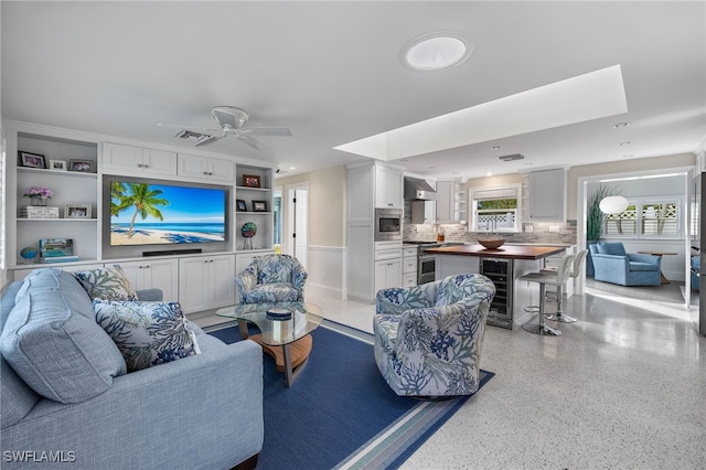 living area featuring light speckled floor, wine cooler, recessed lighting, visible vents, and a ceiling fan