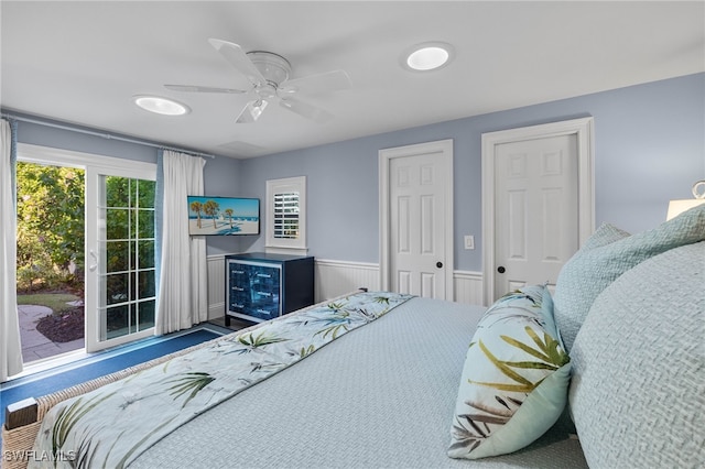 bedroom with a wainscoted wall and ceiling fan