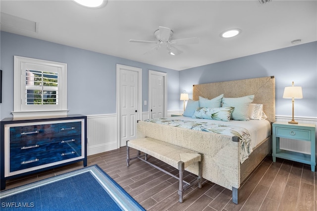 bedroom with a wainscoted wall, ceiling fan, and wood finish floors