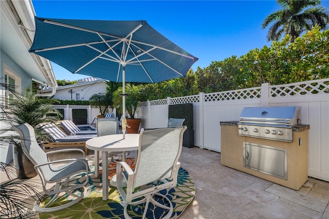 view of patio / terrace featuring outdoor dining space, a fenced backyard, a grill, and area for grilling