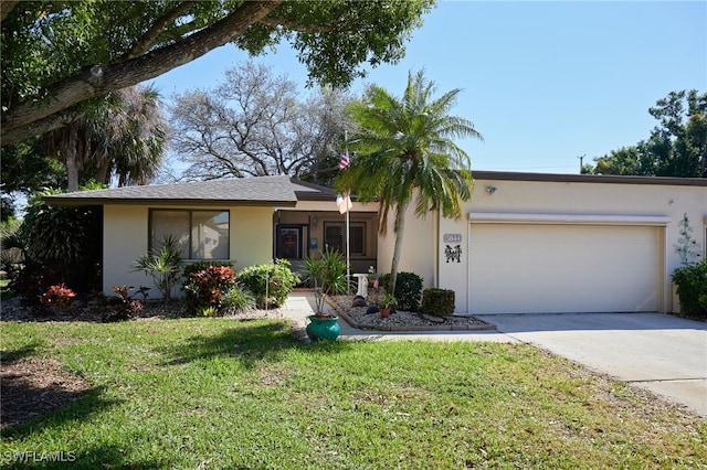 ranch-style home featuring concrete driveway, a front yard, an attached garage, and stucco siding