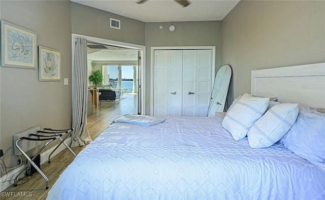 bedroom featuring a closet, visible vents, and wood finished floors