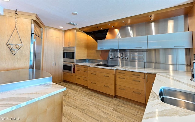 kitchen with recessed lighting, light wood finished floors, visible vents, light stone countertops, and appliances with stainless steel finishes
