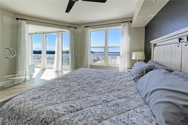 bedroom with access to exterior, multiple windows, ceiling fan, and wood finished floors