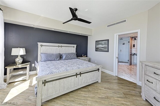 bedroom featuring ensuite bathroom, visible vents, light wood-style flooring, baseboards, and a ceiling fan